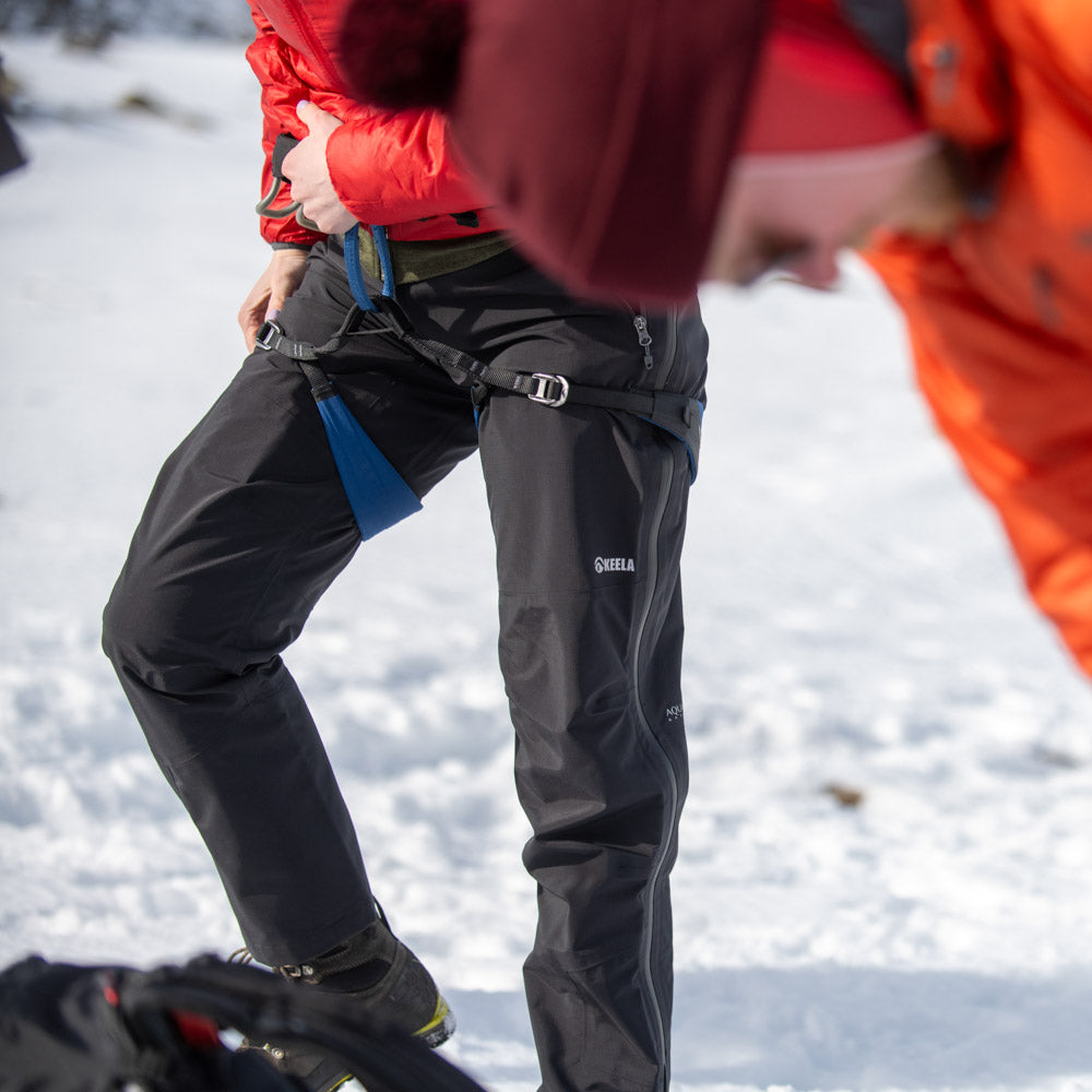 Women's Pinnacle trousers in action - high mountain terrain showing waterproof performance